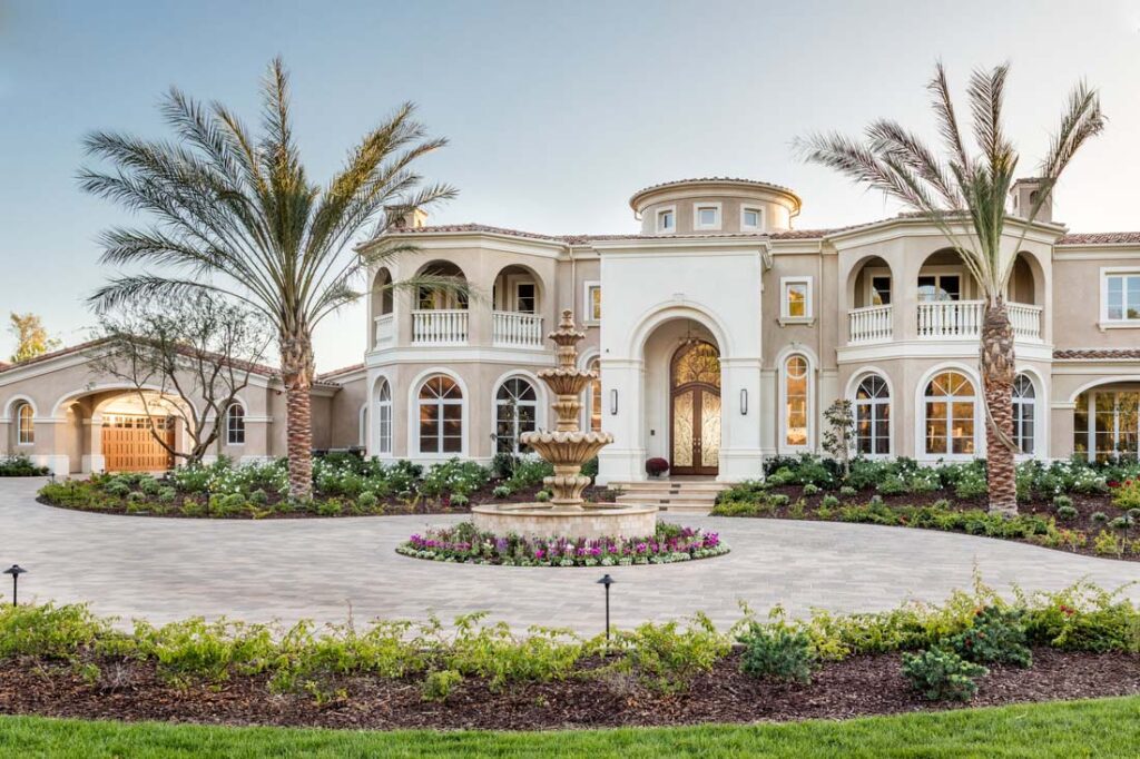 view across circular driveway with fountain of the sprawling grand mediterranean estate in Coto de caza